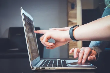 Advisor pointing at a laptop screen during a security review